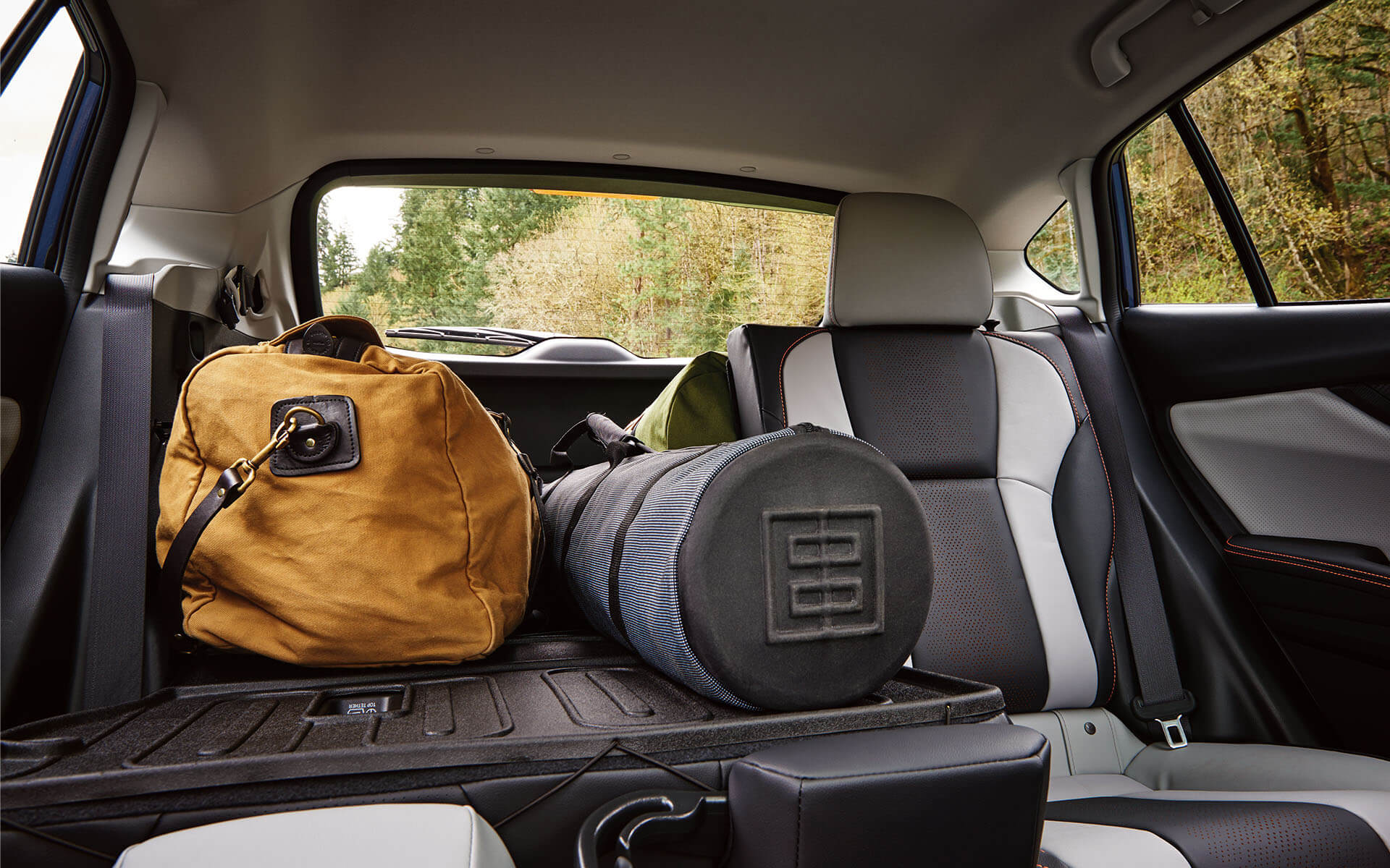Luggage in the rear cargo area of a Subaru Crosstrek with a seat folded down